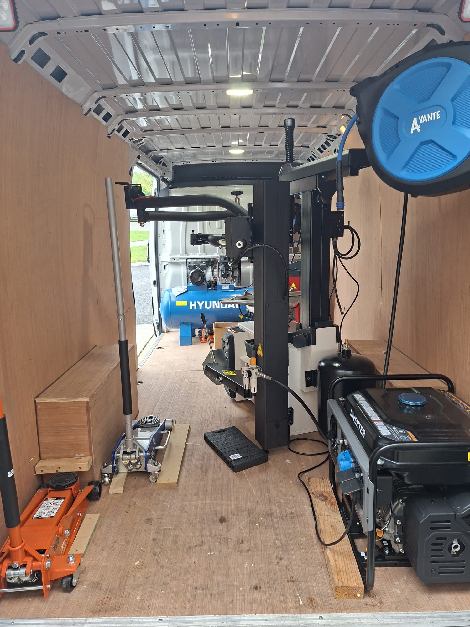 Generator, jacks and air hose reel inside the EJW van